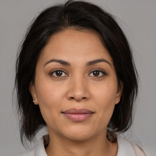 Joyful latino young-adult female with medium  brown hair and brown eyes