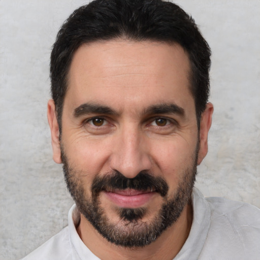 Joyful white adult male with short  black hair and brown eyes
