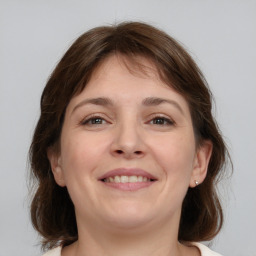 Joyful white young-adult female with medium  brown hair and grey eyes