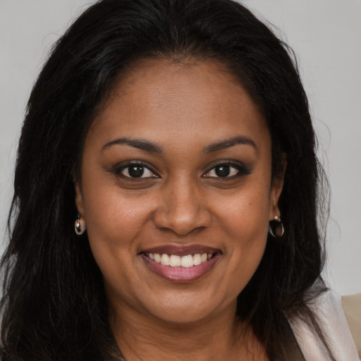 Joyful black young-adult female with long  brown hair and brown eyes