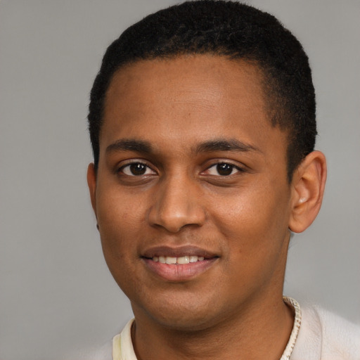 Joyful black young-adult male with short  black hair and brown eyes