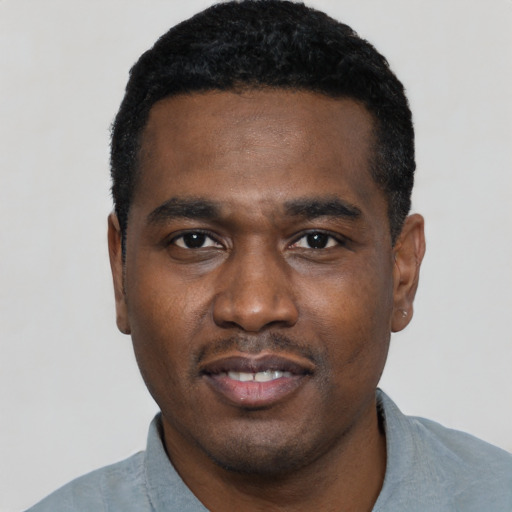Joyful black young-adult male with short  black hair and brown eyes