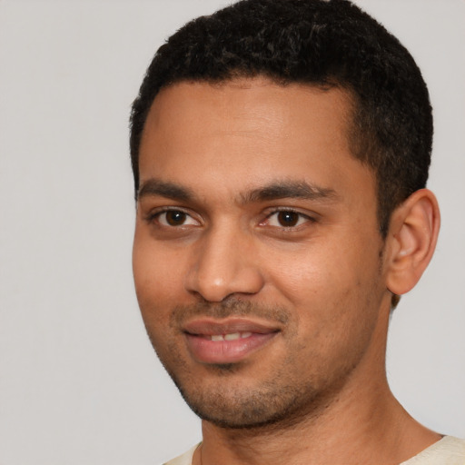Joyful black young-adult male with short  black hair and brown eyes