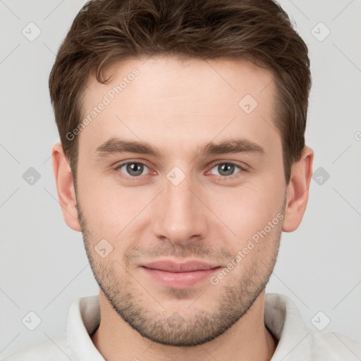 Joyful white young-adult male with short  brown hair and grey eyes