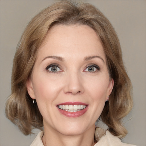 Joyful white adult female with medium  brown hair and blue eyes