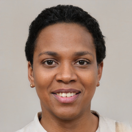 Joyful black young-adult female with short  black hair and brown eyes