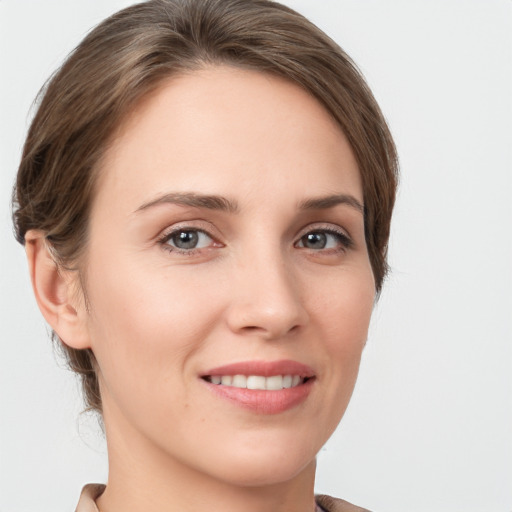 Joyful white young-adult female with medium  brown hair and grey eyes