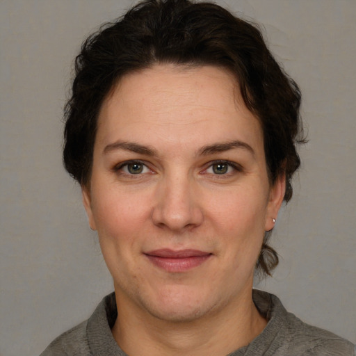 Joyful white adult female with short  brown hair and grey eyes