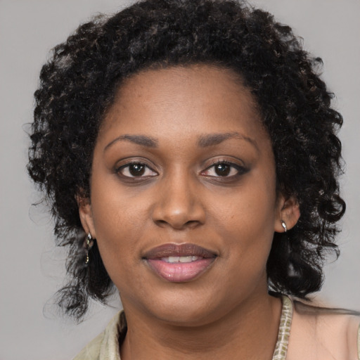 Joyful black young-adult female with long  black hair and brown eyes
