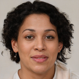 Joyful latino adult female with medium  brown hair and brown eyes