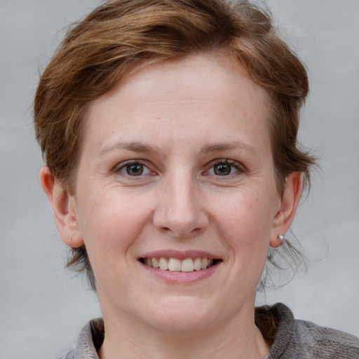 Joyful white young-adult female with medium  brown hair and grey eyes