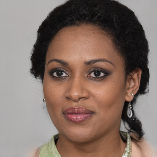 Joyful black young-adult female with long  brown hair and brown eyes