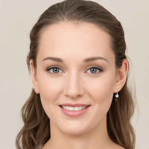 Joyful white young-adult female with long  brown hair and green eyes