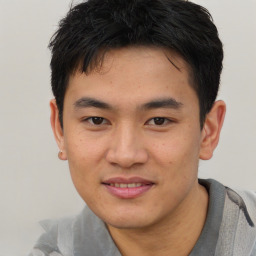 Joyful asian young-adult male with short  brown hair and brown eyes