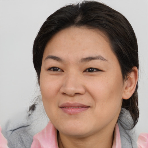 Joyful asian adult female with medium  brown hair and brown eyes