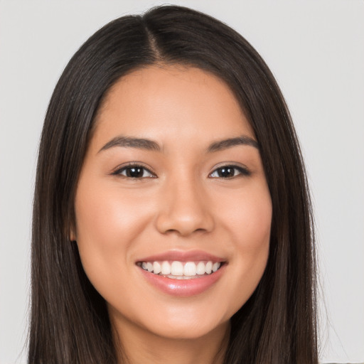 Joyful latino young-adult female with long  brown hair and brown eyes