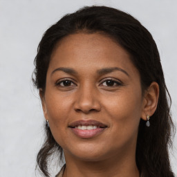 Joyful latino young-adult female with long  brown hair and brown eyes