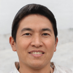 Joyful asian adult male with short  black hair and brown eyes