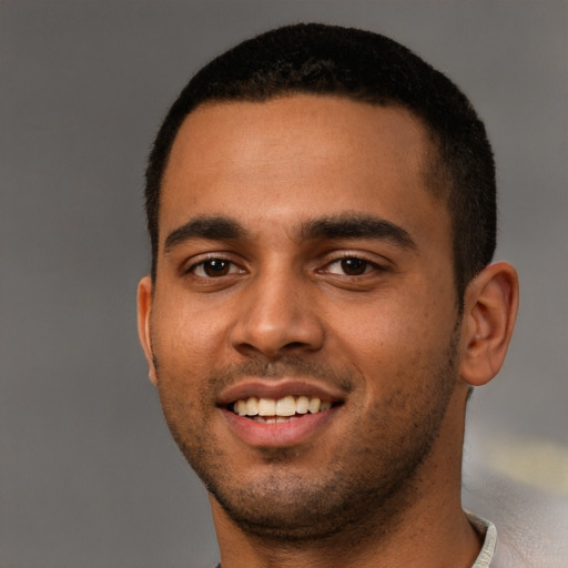 Joyful latino young-adult male with short  black hair and brown eyes