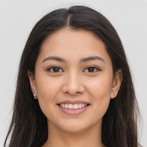 Joyful latino young-adult female with long  brown hair and brown eyes