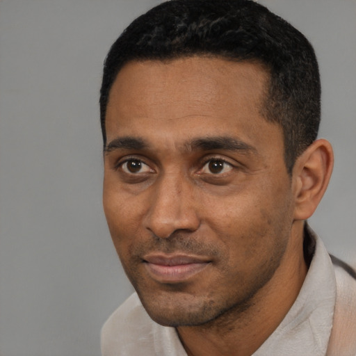 Joyful black young-adult male with short  black hair and brown eyes