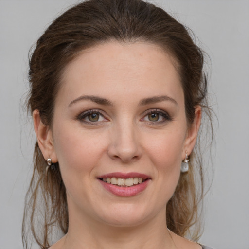 Joyful white young-adult female with medium  brown hair and grey eyes