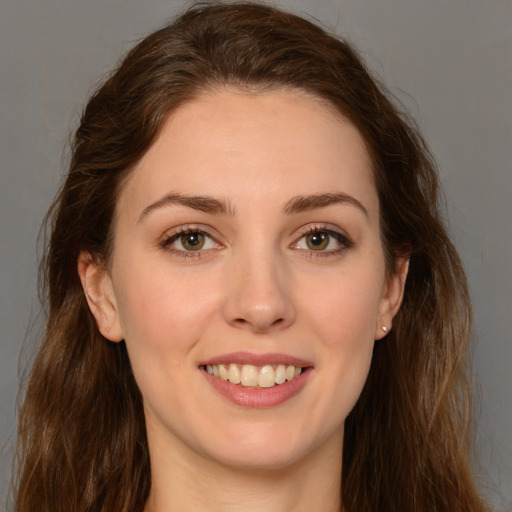 Joyful white young-adult female with long  brown hair and brown eyes