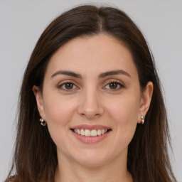 Joyful white young-adult female with long  brown hair and brown eyes