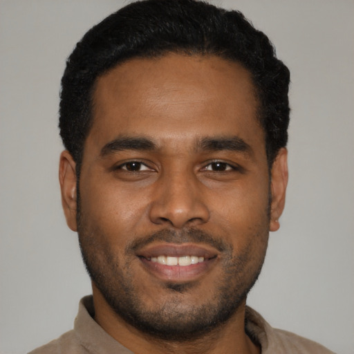 Joyful black young-adult male with short  black hair and brown eyes