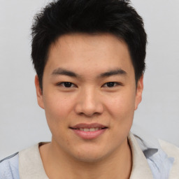 Joyful asian young-adult male with short  black hair and brown eyes