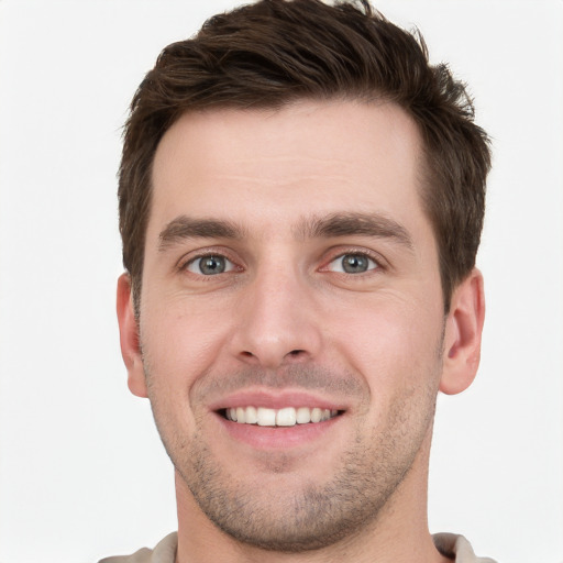 Joyful white young-adult male with short  brown hair and grey eyes