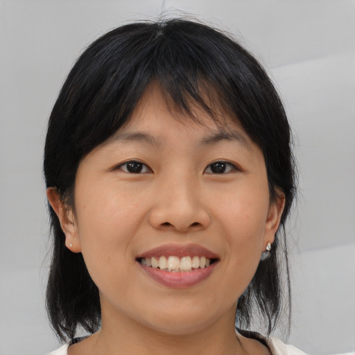 Joyful asian young-adult female with medium  brown hair and brown eyes