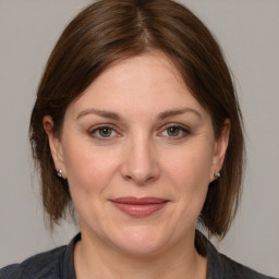 Joyful white adult female with medium  brown hair and grey eyes