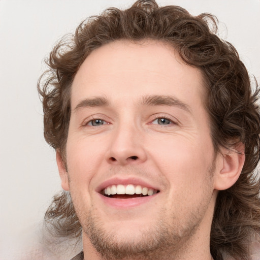 Joyful white young-adult male with medium  brown hair and blue eyes