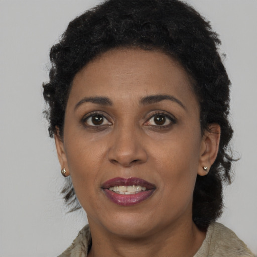 Joyful black young-adult female with short  black hair and brown eyes