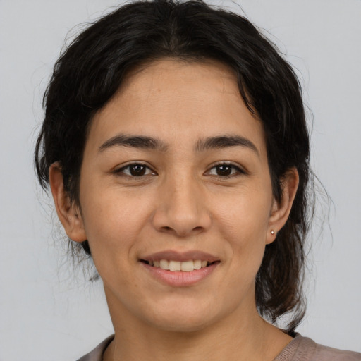 Joyful latino young-adult female with medium  brown hair and brown eyes