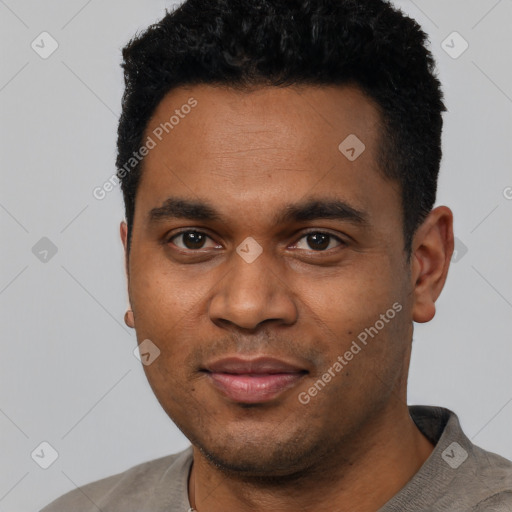 Joyful black young-adult male with short  black hair and brown eyes