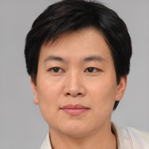 Joyful asian adult male with short  brown hair and brown eyes