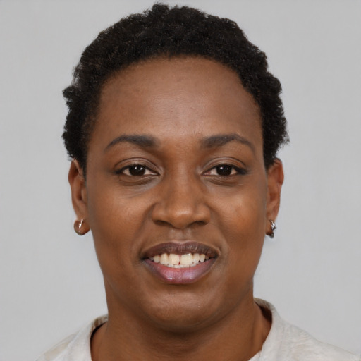 Joyful black young-adult female with short  black hair and brown eyes