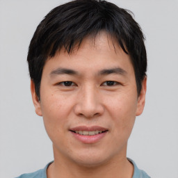 Joyful asian young-adult male with short  brown hair and brown eyes