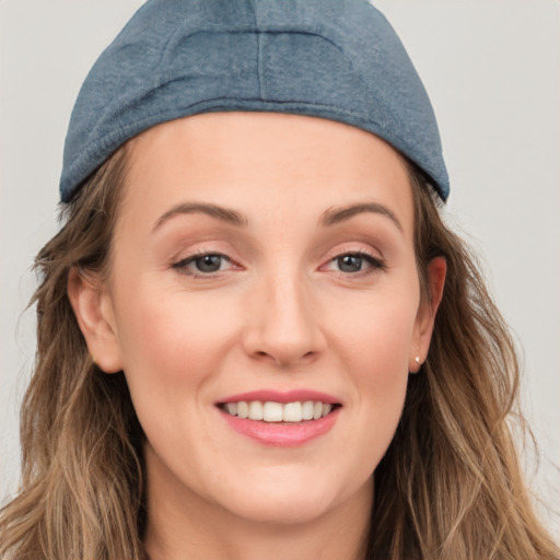 Joyful white young-adult female with long  brown hair and blue eyes