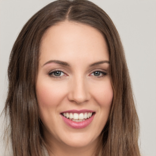 Joyful white young-adult female with long  brown hair and brown eyes