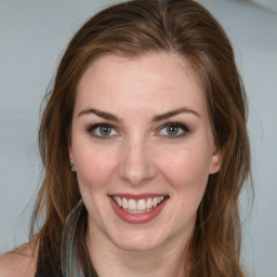 Joyful white young-adult female with long  brown hair and blue eyes