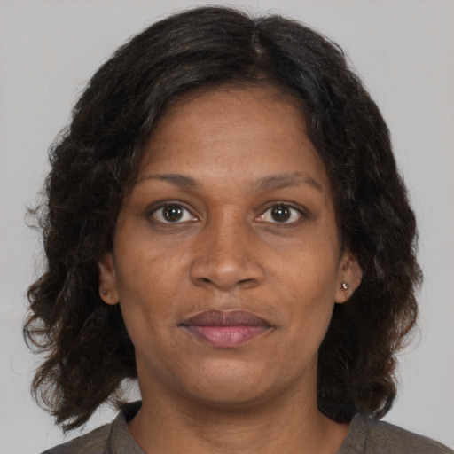 Joyful black adult female with medium  brown hair and brown eyes