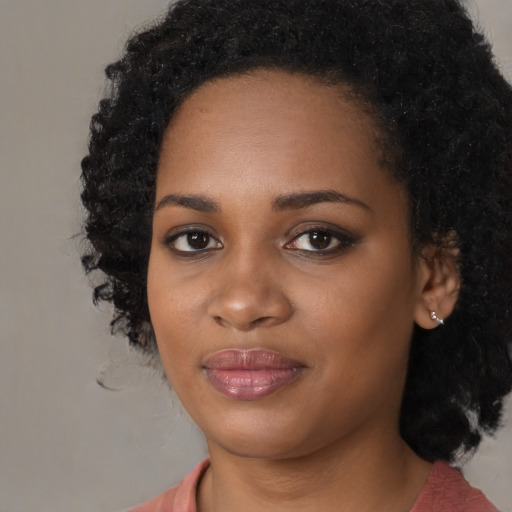 Joyful black young-adult female with medium  black hair and brown eyes