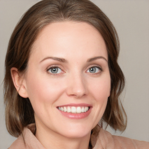 Joyful white young-adult female with medium  brown hair and blue eyes