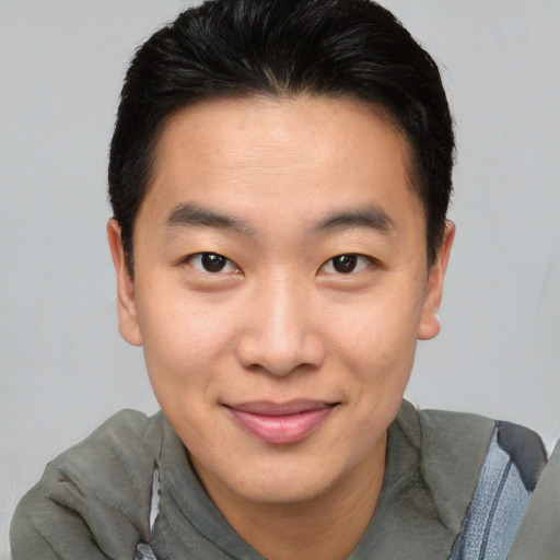 Joyful asian young-adult male with short  brown hair and brown eyes