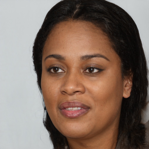 Joyful black adult female with long  black hair and brown eyes