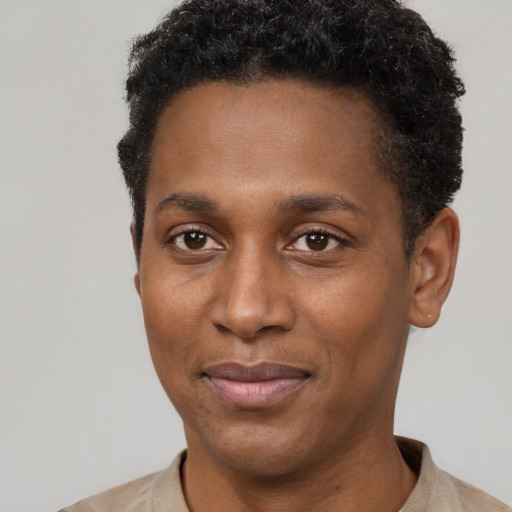 Joyful black young-adult male with short  black hair and brown eyes