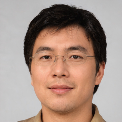 Joyful asian adult male with short  brown hair and brown eyes